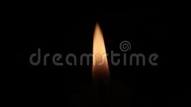 一支蜡烛的橙色小火焰在黑暗中燃烧。 纯黑色背景。 丧葬或精神插图